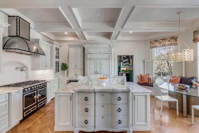 kitchen with a kitchen island, white cabinetry, double oven range, light stone countertops, and breakfast area