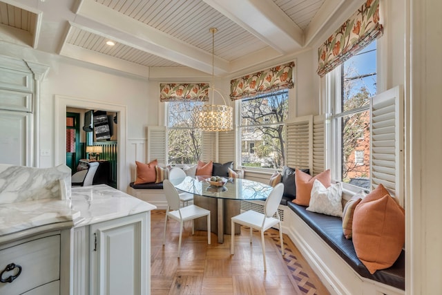 dining room featuring a decorative wall, beam ceiling, and an inviting chandelier