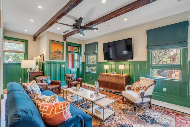 living area with ceiling fan, beamed ceiling, wainscoting, and recessed lighting