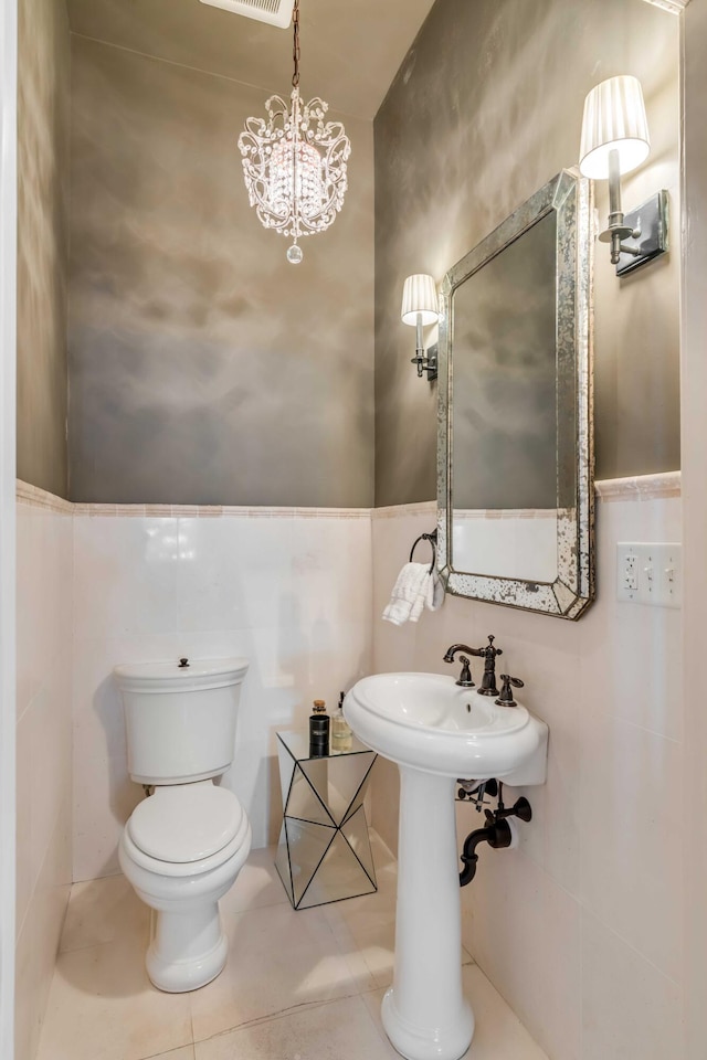 bathroom with tile patterned flooring, visible vents, tile walls, and toilet