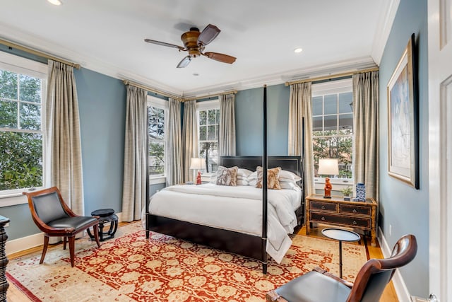 bedroom with ornamental molding, multiple windows, and wood finished floors