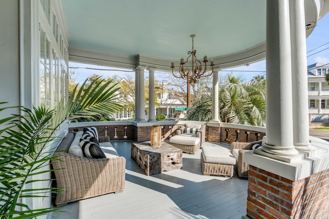 sunroom / solarium with decorative columns and an inviting chandelier