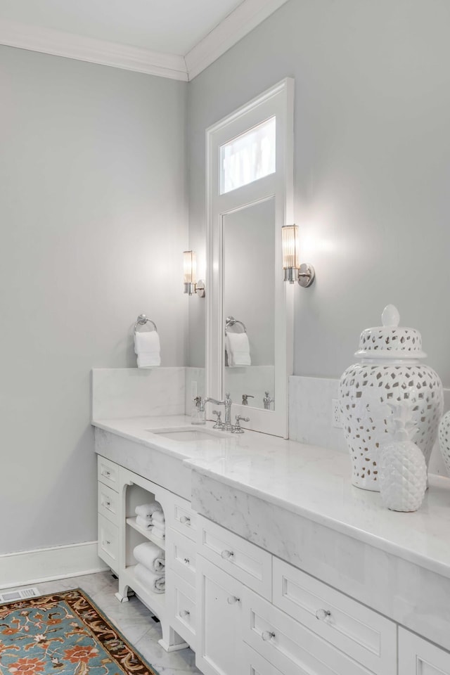 bathroom with ornamental molding, vanity, and baseboards