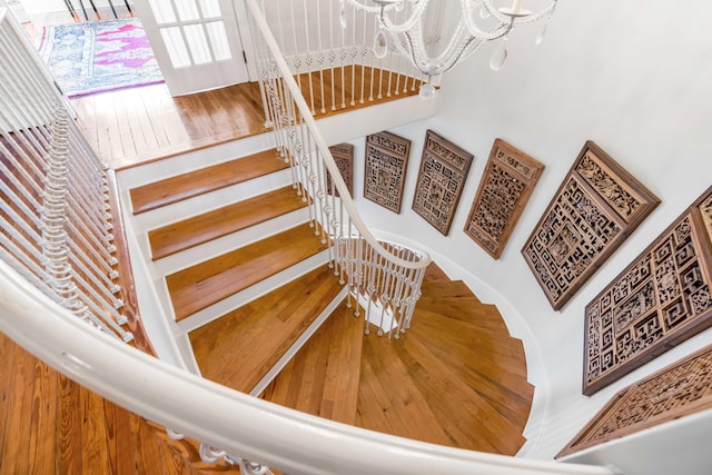 staircase with a notable chandelier