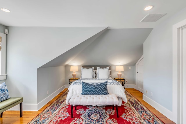 bedroom featuring lofted ceiling, recessed lighting, visible vents, light wood-style flooring, and baseboards