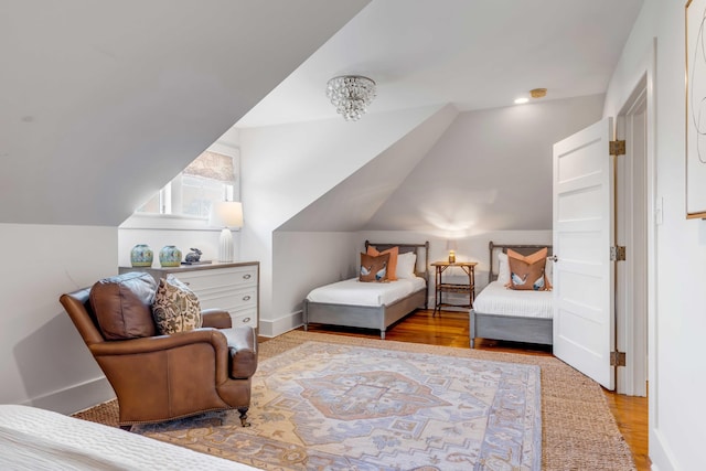 bedroom with lofted ceiling, wood finished floors, and baseboards