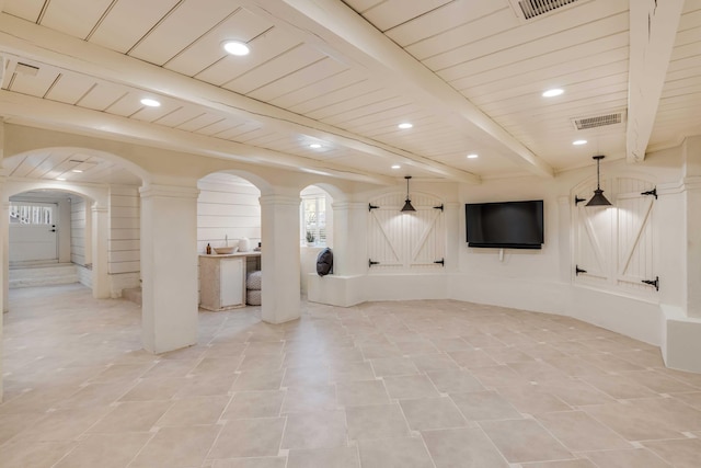 basement featuring arched walkways, recessed lighting, visible vents, a barn door, and wood ceiling