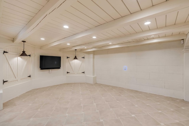 finished basement featuring concrete block wall, wooden ceiling, a barn door, and recessed lighting