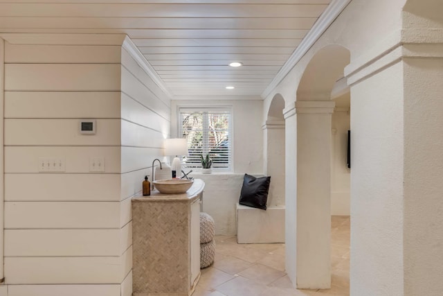 bathroom with ornate columns, a sink, tile patterned flooring, and crown molding