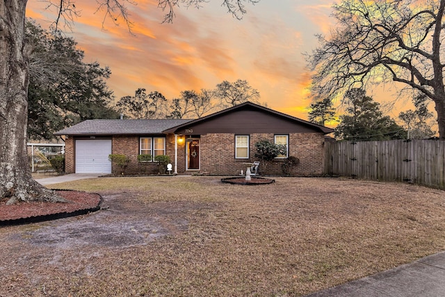 view of front of home featuring brick siding, fence, and a garage