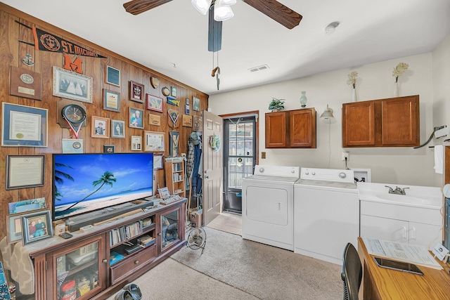 washroom featuring visible vents, cabinet space, separate washer and dryer, wooden walls, and ceiling fan