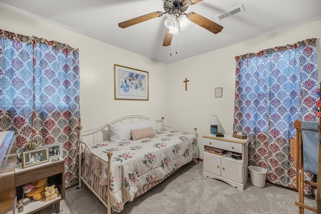 carpeted bedroom featuring visible vents and a ceiling fan