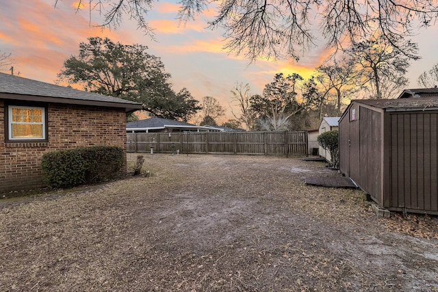 view of yard featuring an outbuilding, a fenced backyard, and a shed