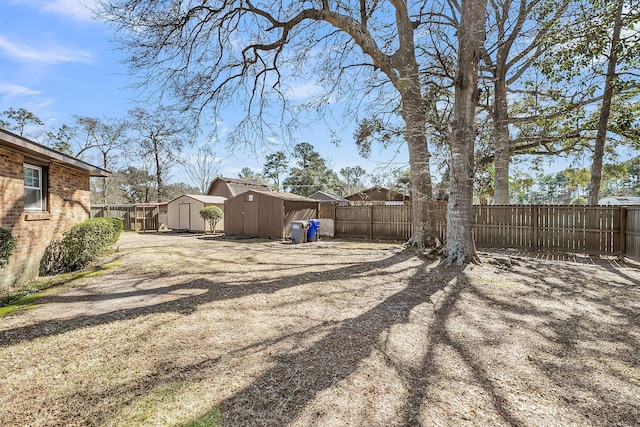 view of yard with an outbuilding, a storage shed, and a fenced backyard