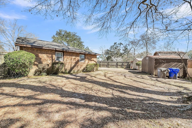 view of yard featuring a shed, an outdoor structure, and a fenced backyard