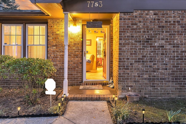 doorway to property with brick siding