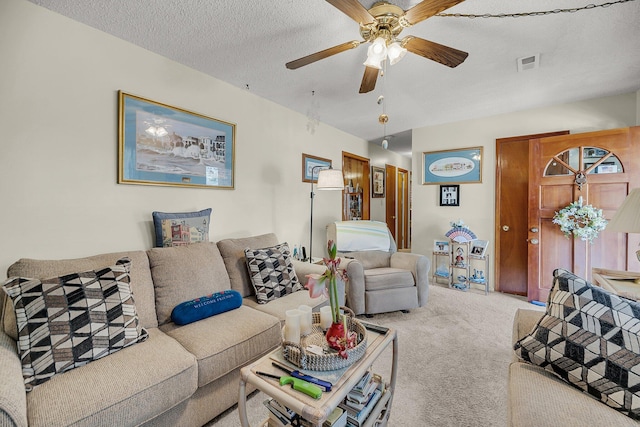 living area featuring a ceiling fan, carpet, visible vents, and a textured ceiling