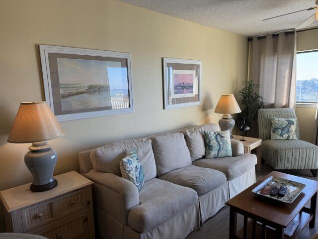 living room with ceiling fan and a textured ceiling