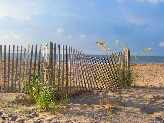 view of yard featuring a water view and a beach view