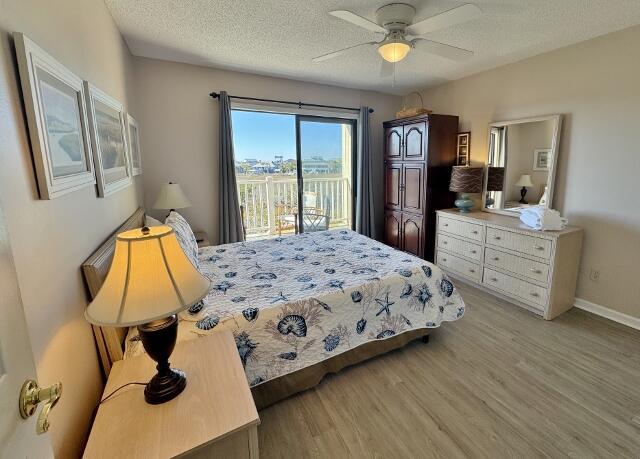 bedroom featuring access to exterior, ceiling fan, light hardwood / wood-style flooring, and a textured ceiling