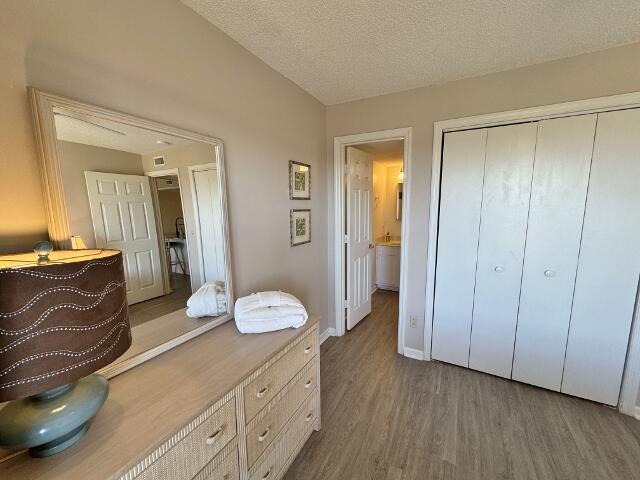 bedroom featuring a textured ceiling, a closet, and dark wood-type flooring