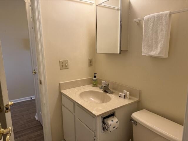 bathroom featuring vanity, wood-type flooring, and toilet