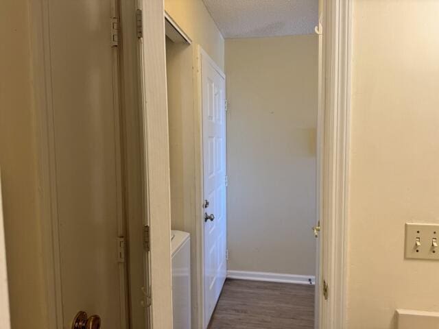 corridor with dark hardwood / wood-style flooring and a textured ceiling