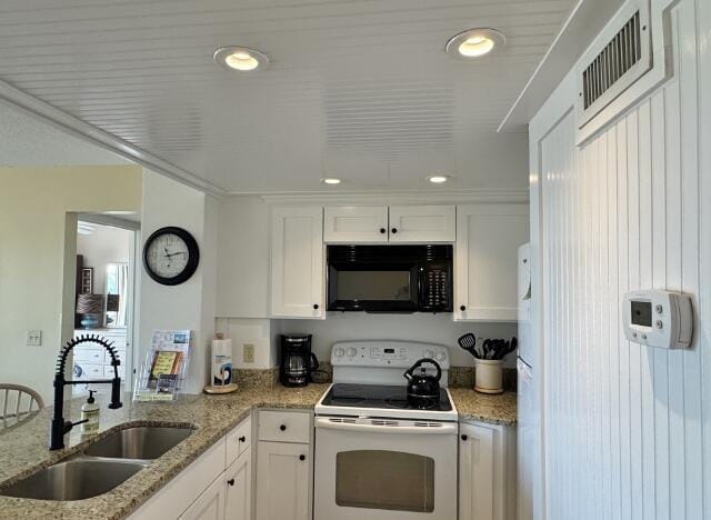 kitchen featuring white cabinets, light stone counters, white range with electric stovetop, and sink