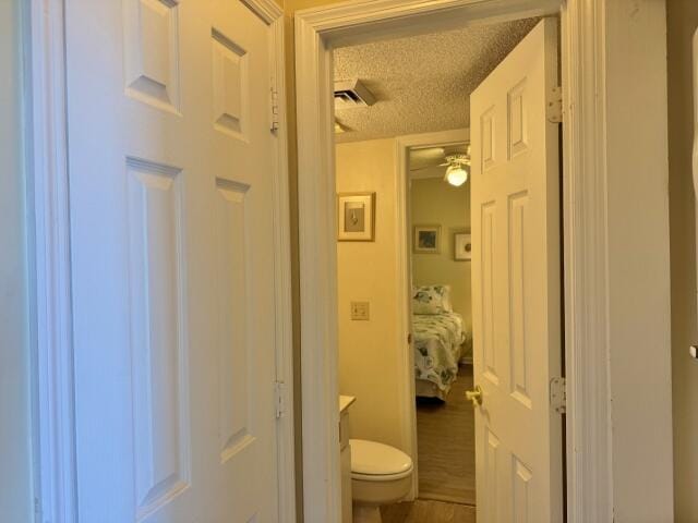 bathroom with ceiling fan, toilet, a textured ceiling, and vanity