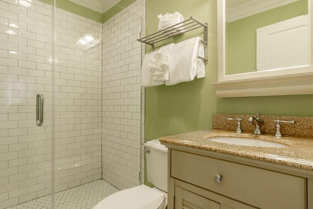 bathroom featuring toilet, a stall shower, crown molding, and vanity