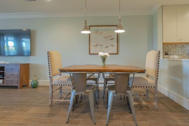 dining room featuring baseboards, crown molding, and wood finish floors