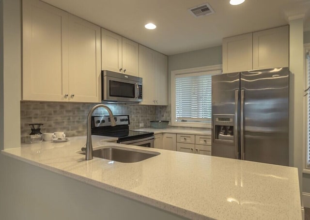 kitchen with light stone counters, recessed lighting, visible vents, backsplash, and appliances with stainless steel finishes