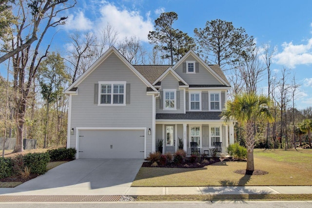 view of front of home featuring a porch, an attached garage, driveway, roof with shingles, and a front yard