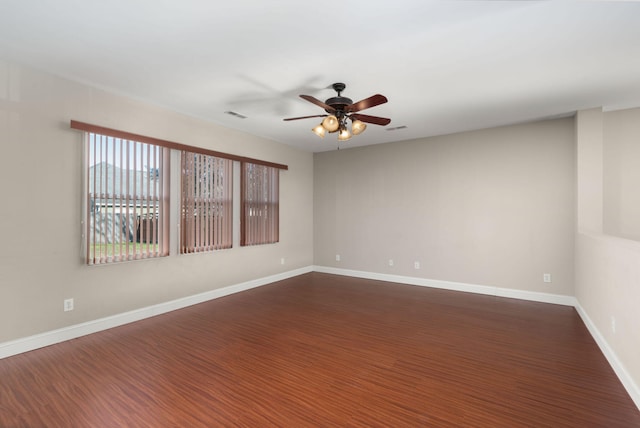 empty room with ceiling fan and dark hardwood / wood-style flooring