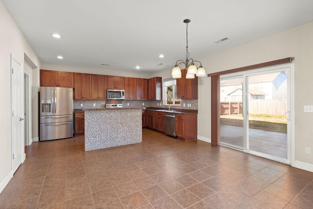 kitchen featuring sink, a center island, hanging light fixtures, a chandelier, and appliances with stainless steel finishes