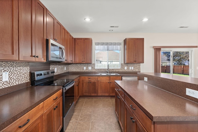 kitchen featuring backsplash, sink, light tile patterned flooring, and appliances with stainless steel finishes