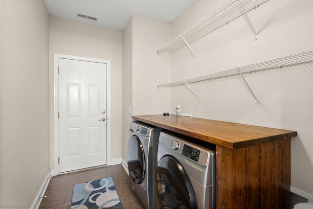 washroom featuring washer and dryer and dark tile patterned floors