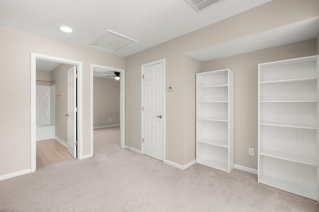 unfurnished bedroom featuring light colored carpet and connected bathroom