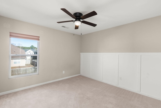 carpeted spare room with ceiling fan