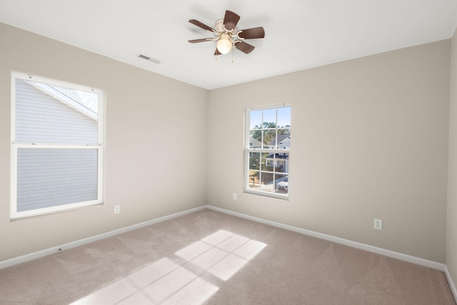 carpeted spare room with ceiling fan