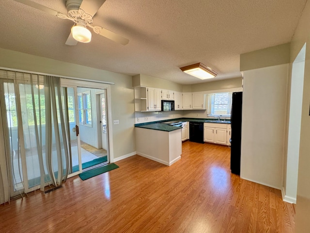 kitchen with black appliances, sink, light wood-type flooring, ceiling fan, and white cabinets