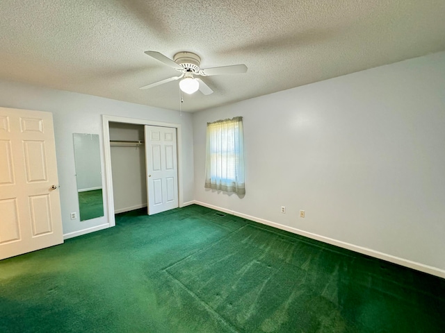 unfurnished bedroom with a closet, a textured ceiling, dark carpet, and ceiling fan