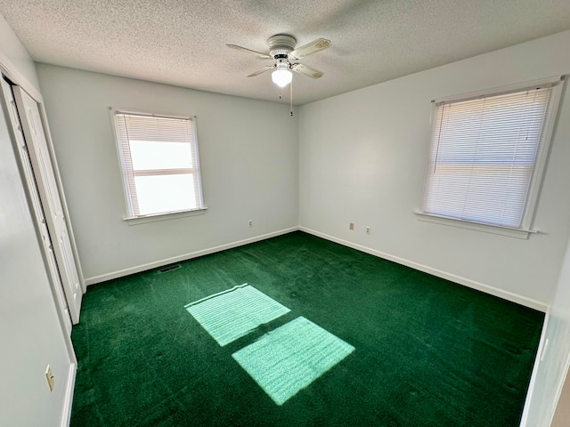 carpeted spare room featuring a textured ceiling, golf simulator, and ceiling fan