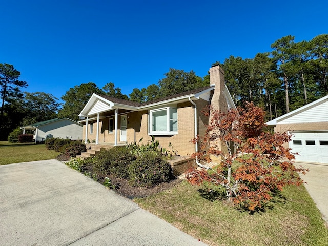 view of front facade featuring a porch, a front yard, and a garage