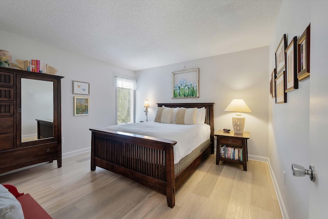 bedroom with light hardwood / wood-style floors and a textured ceiling