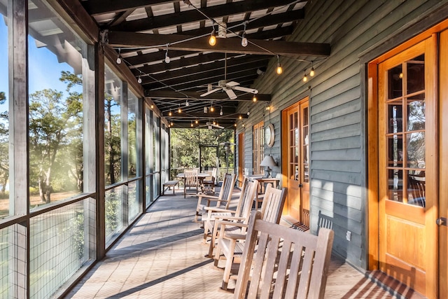 unfurnished sunroom with vaulted ceiling and ceiling fan