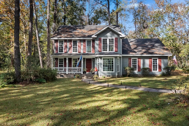 colonial house featuring covered porch and a front yard