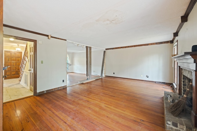 unfurnished living room with ornamental molding and light wood-type flooring