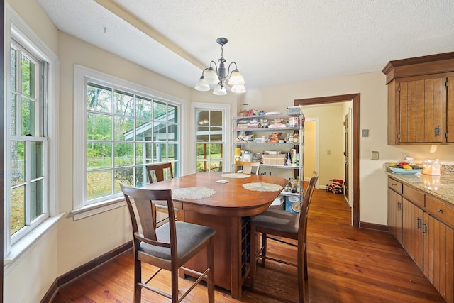 dining area with dark hardwood / wood-style floors, a chandelier, and a textured ceiling