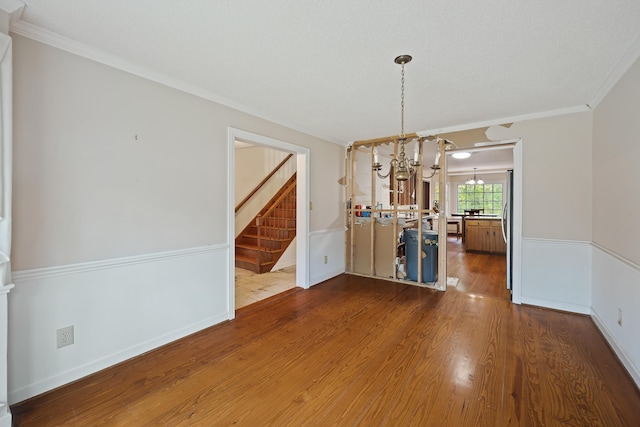 interior space featuring an inviting chandelier, crown molding, and dark wood-type flooring